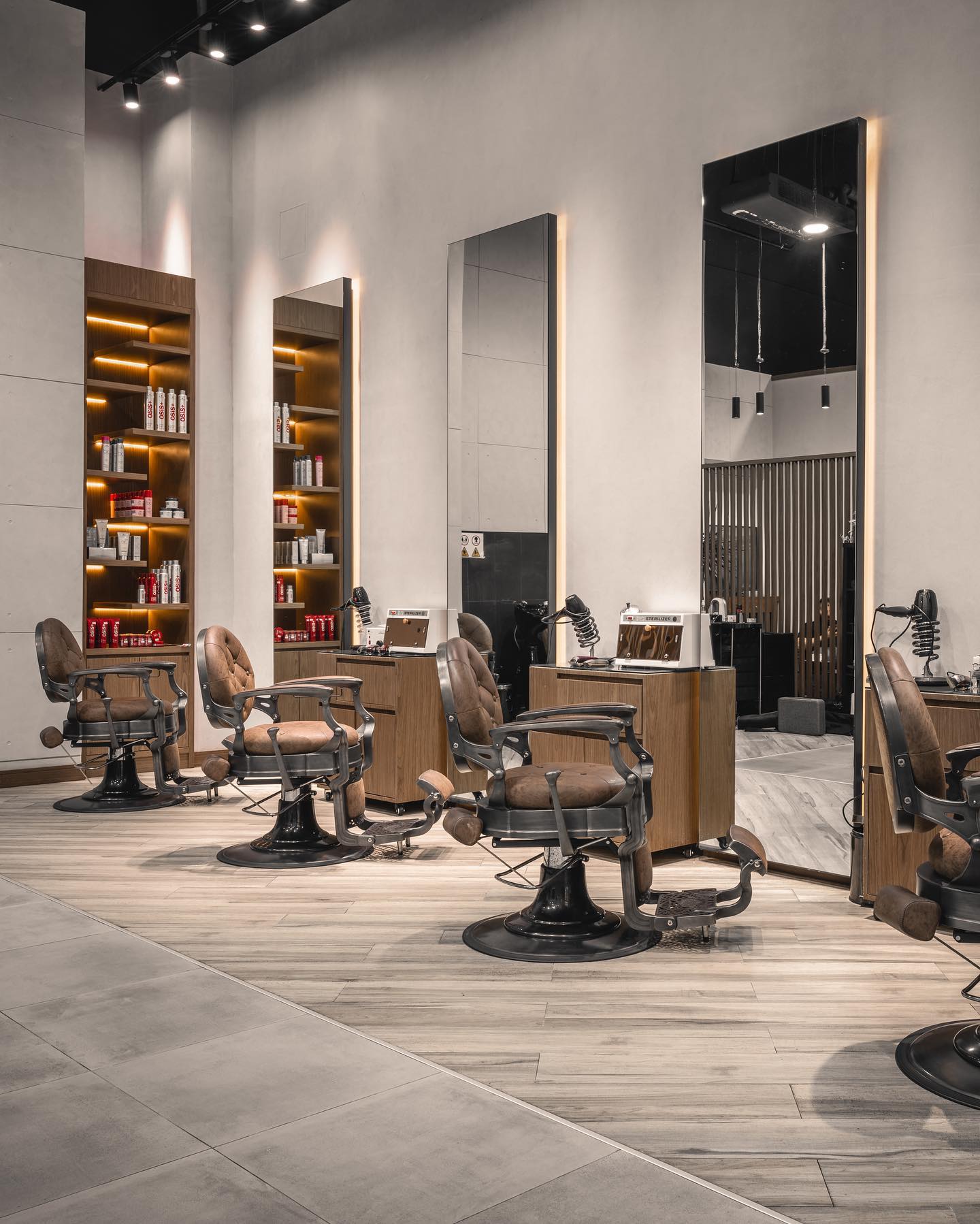 Clean interior of Scissors and Razors Gents Salon with leather barber chairs and product shelving